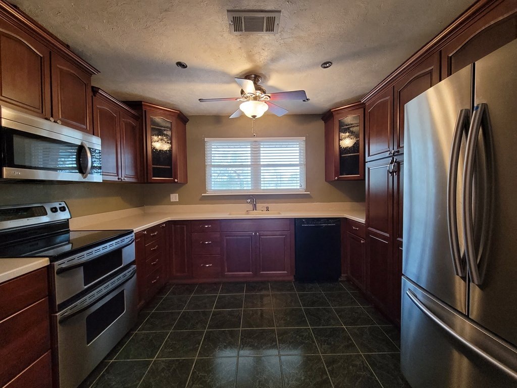 a kitchen with stainless steel appliances and a ceiling fan