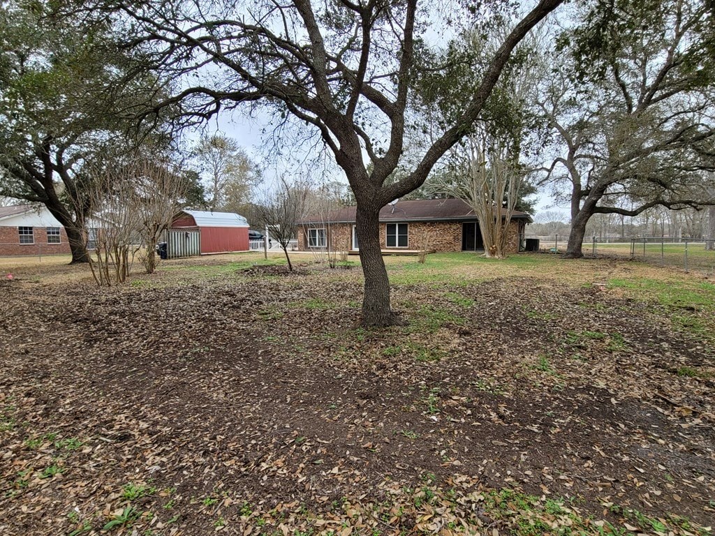 a yard with a tree in front of a house