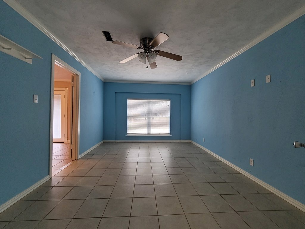 a blue room with a ceiling fan and a tiled floor