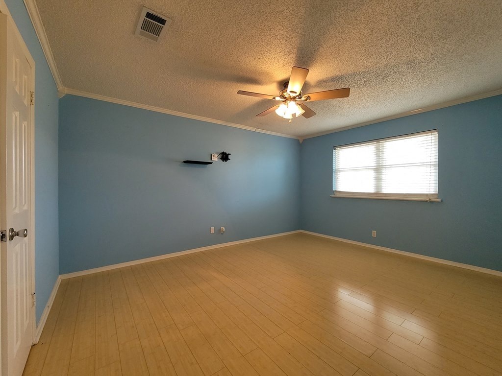 an empty room with a ceiling fan and a window