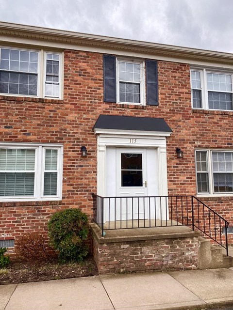 a brick building with a porch and a white door