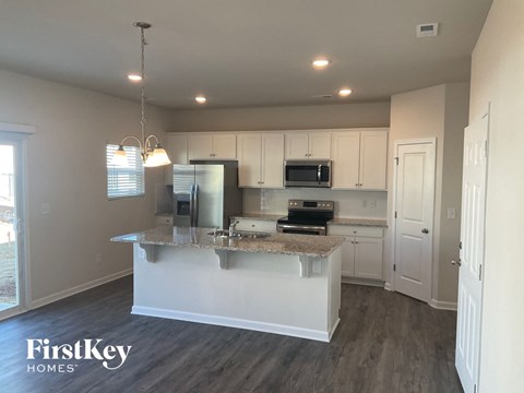 A kitchen with a granite countertop and a FirstKey Homes logo.