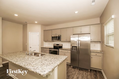 A kitchen with a granite countertop and stainless steel appliances.