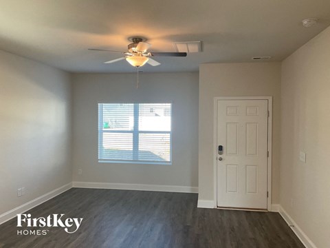 an empty room with a ceiling fan and a window