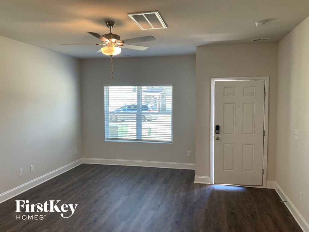an empty room with a white door and a ceiling fan