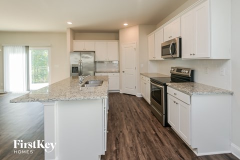 A kitchen with white cabinets and a granite countertop.