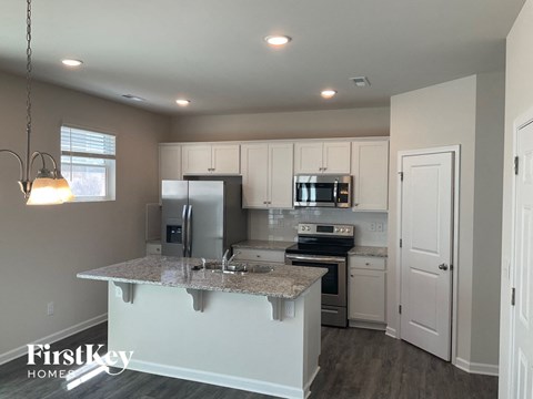 A kitchen with a granite countertop and a refrigerator.