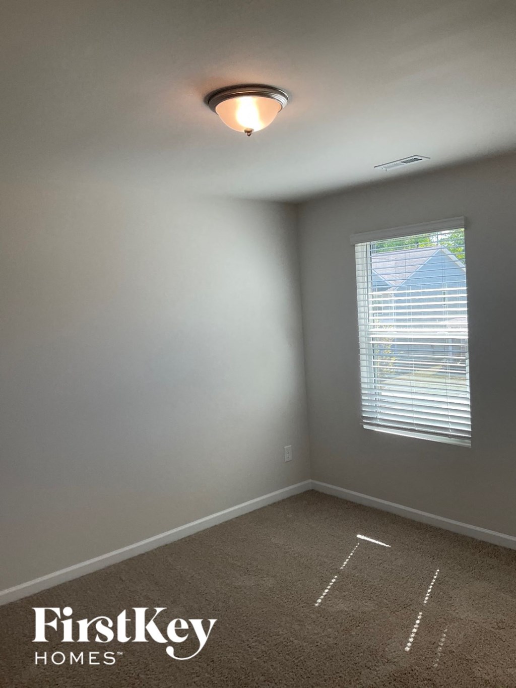 a empty room with a window and a light on the ceiling