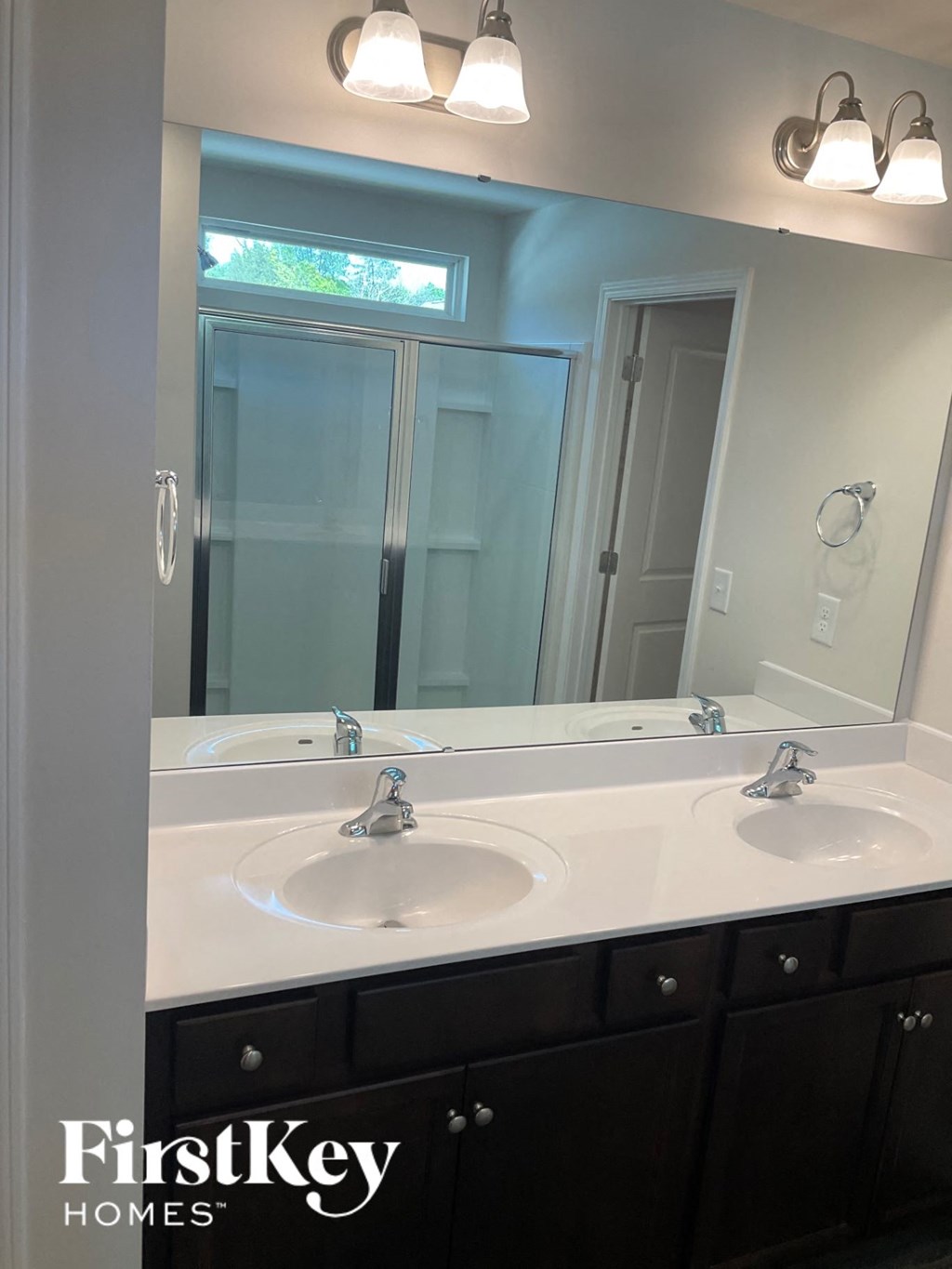 a bathroom with two sinks and a large mirror