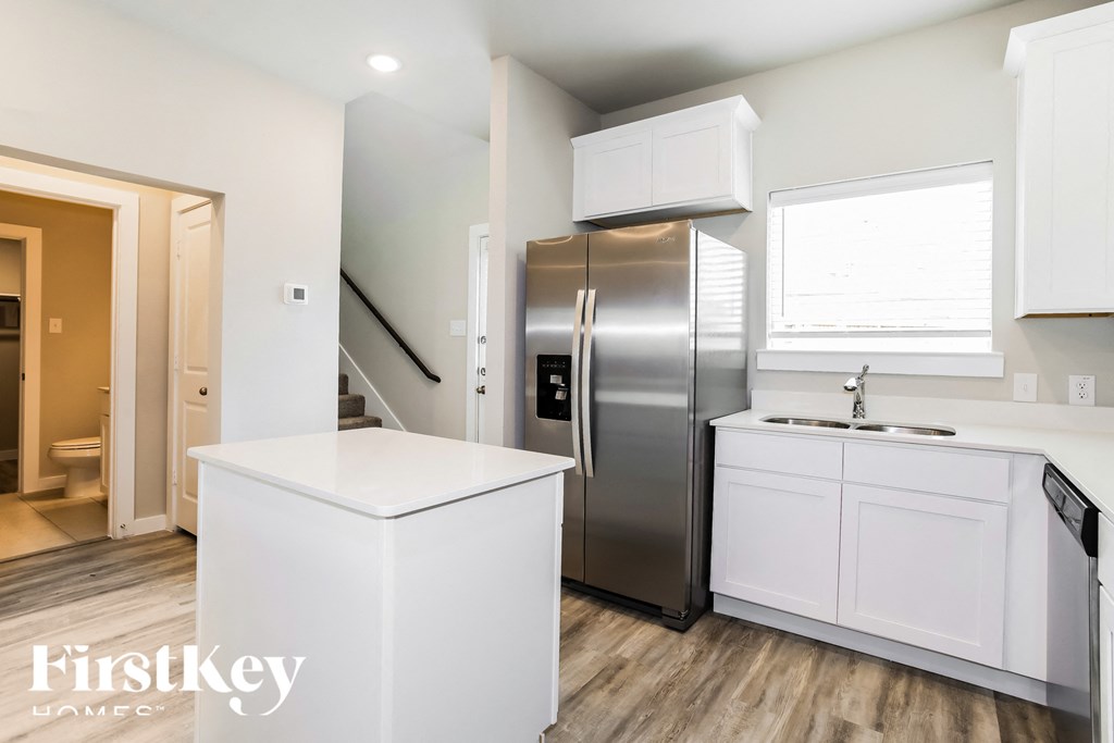 a kitchen with white cabinets and a stainless steel refrigerator