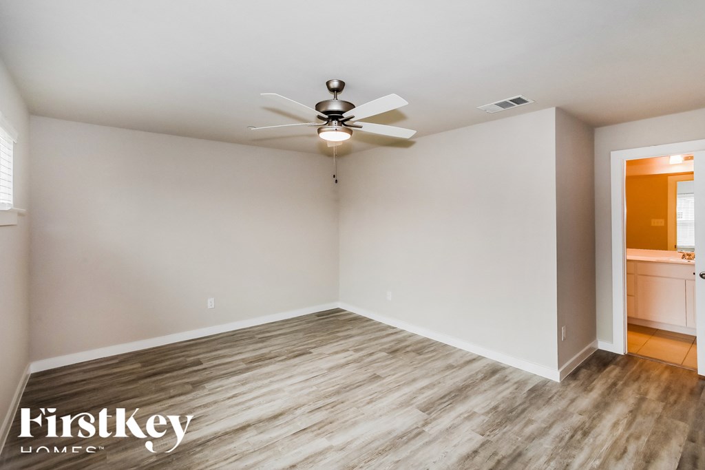 the living room of an empty house with a ceiling fan