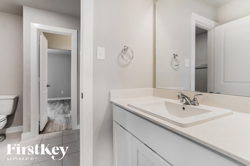a white bathroom with a sink and a mirror