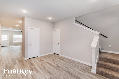 A spacious room with a staircase leading to the second floor.
