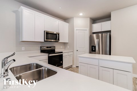A kitchen with white cabinets and stainless steel appliances.