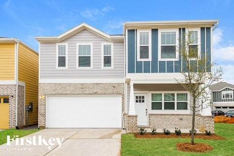 a white house with a white garage door and a yellow house