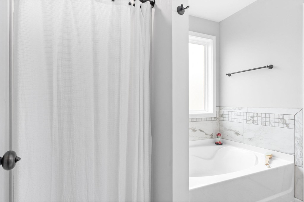 a white bathroom with a shower curtain and a sink