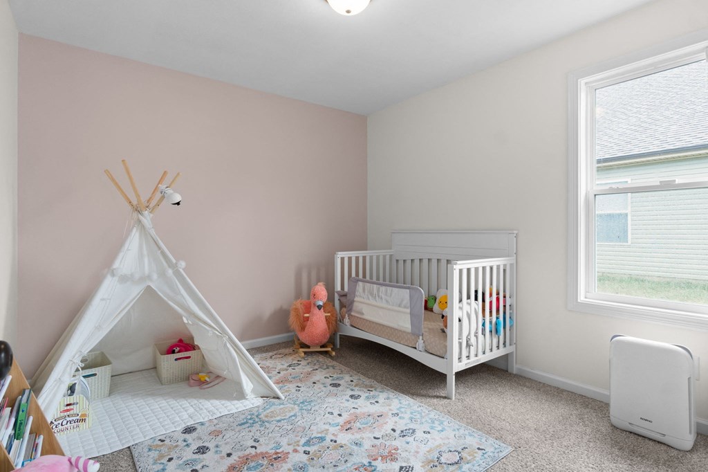 a nursery with a white crib and a teepee
