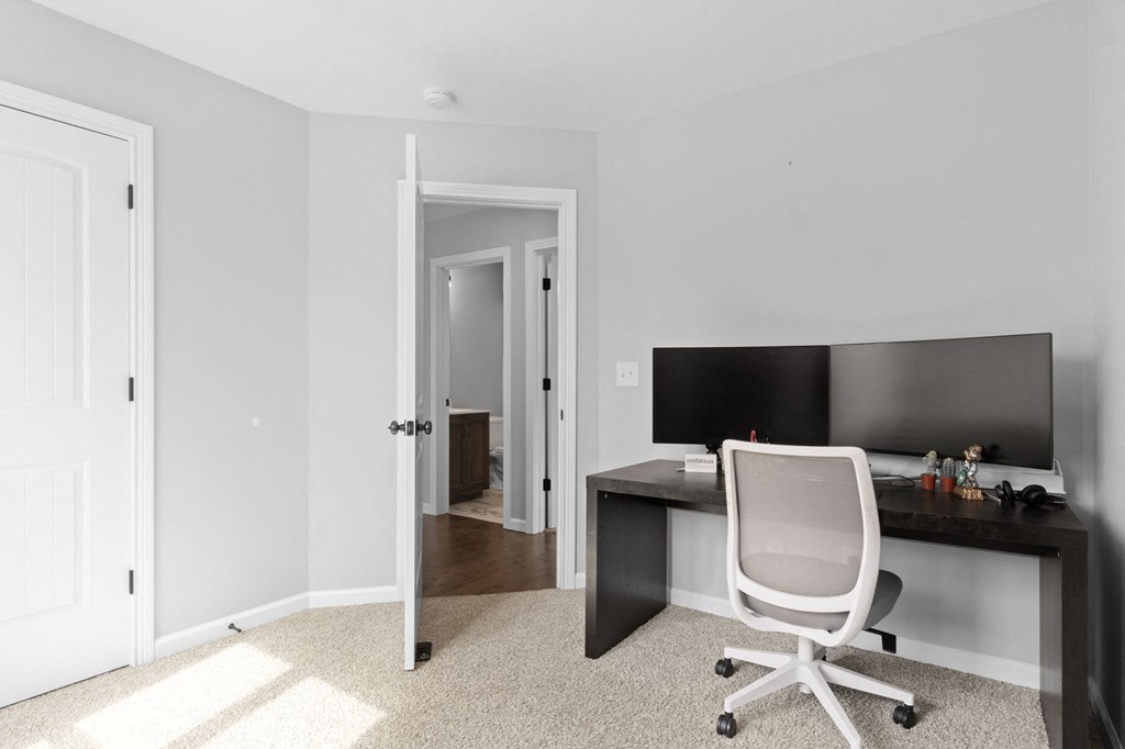 a bedroom with a desk with a chair and a tv
