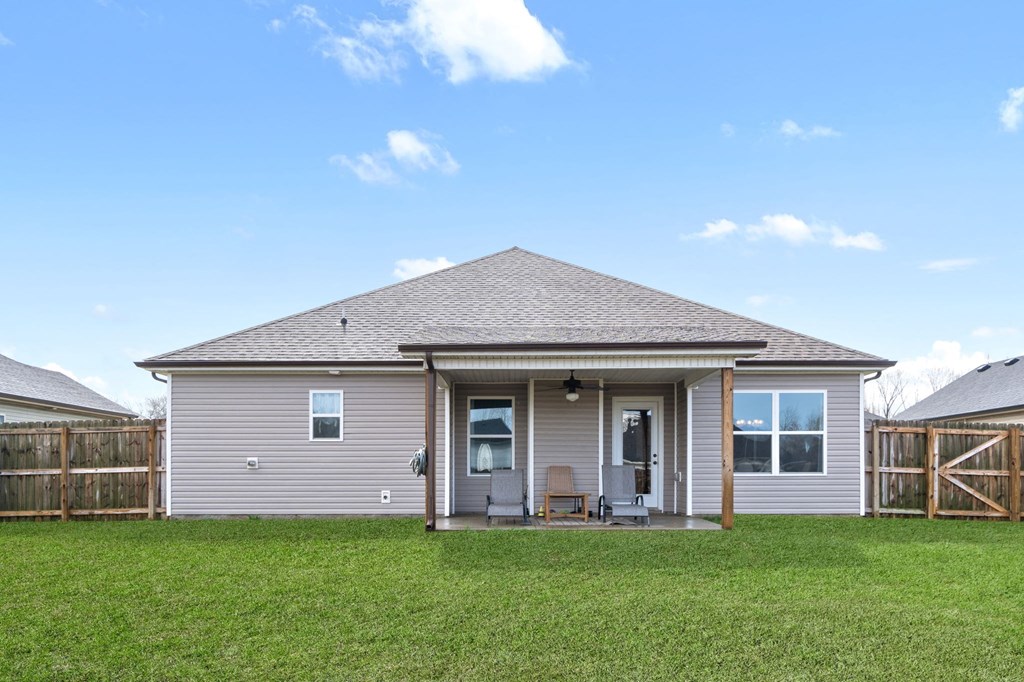 the front of a house with a lawn and a fence