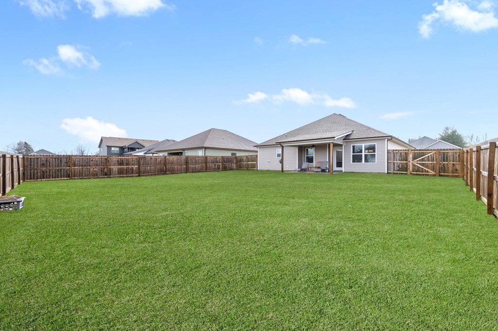 the backyard of a house with a yard and a fence