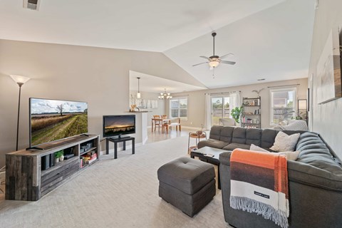A living room with a grey couch and a television on the left side.