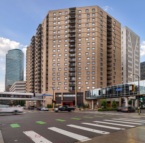 a view of a city street with tall buildings and a train