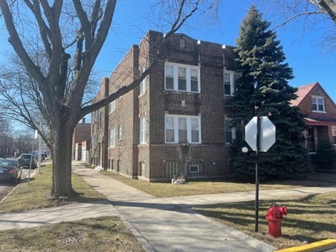 a red fire hydrant in front of a brick building