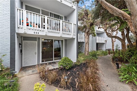 the front of a house with a white door and a balcony