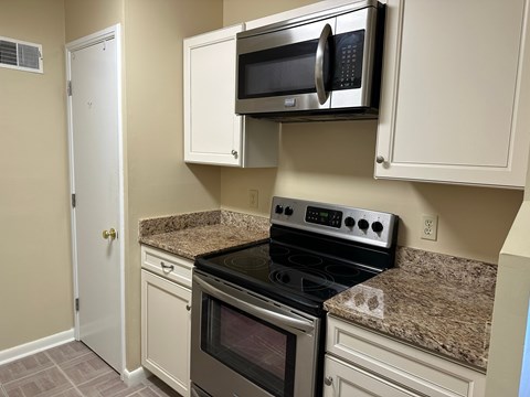A kitchen with a stove, oven, and microwave.