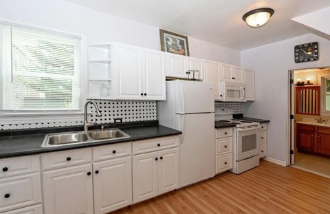a kitchen with white cabinets and a sink and a refrigerator