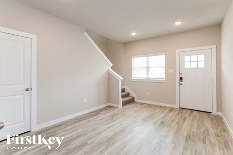 A spacious room with a staircase leading to the second floor.
