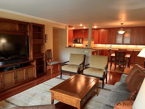 a living room and kitchen with a couch and a table