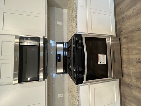 A black microwave oven is installed in a kitchen.
