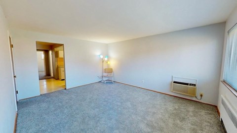 an empty living room with white walls and carpet