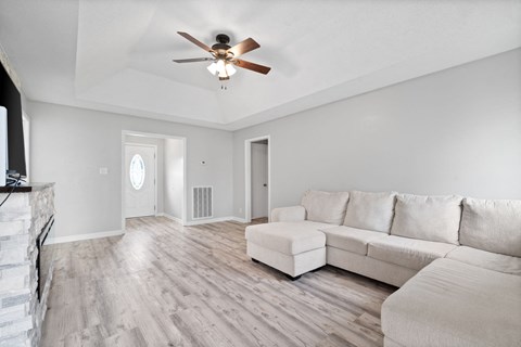 a living room with a couch and a ceiling fan