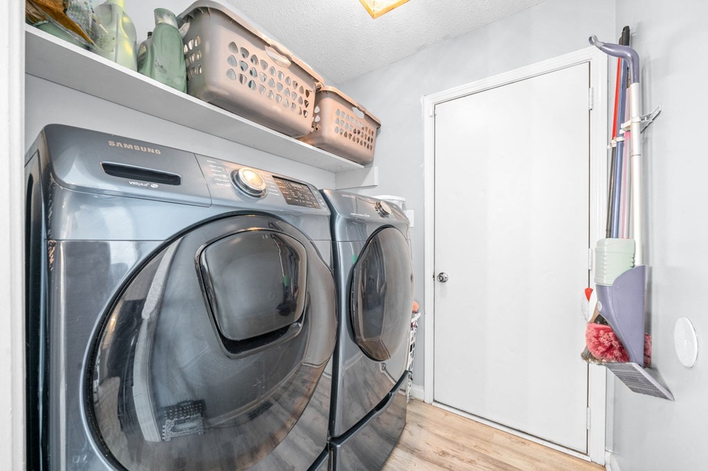 a washer and dryer in a laundry room with a white door