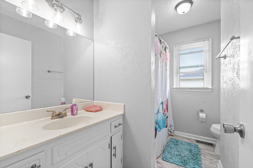 a bathroom with a sink and a shower and a mirror