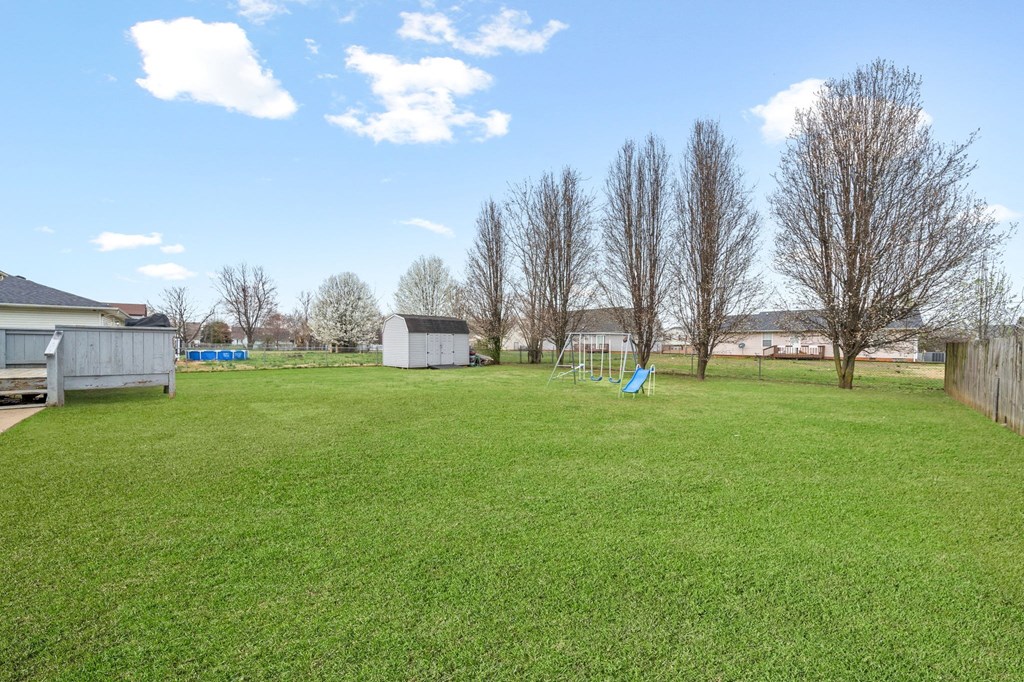 a yard with a swing set in the grass