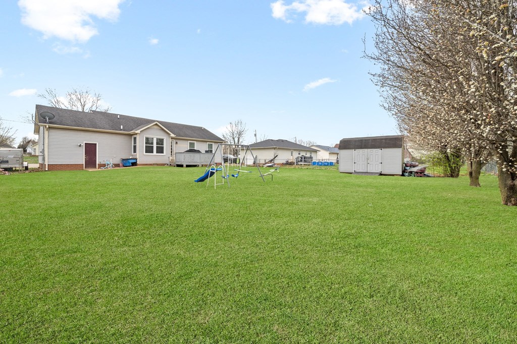 a backyard with a yard with a swing set and a house