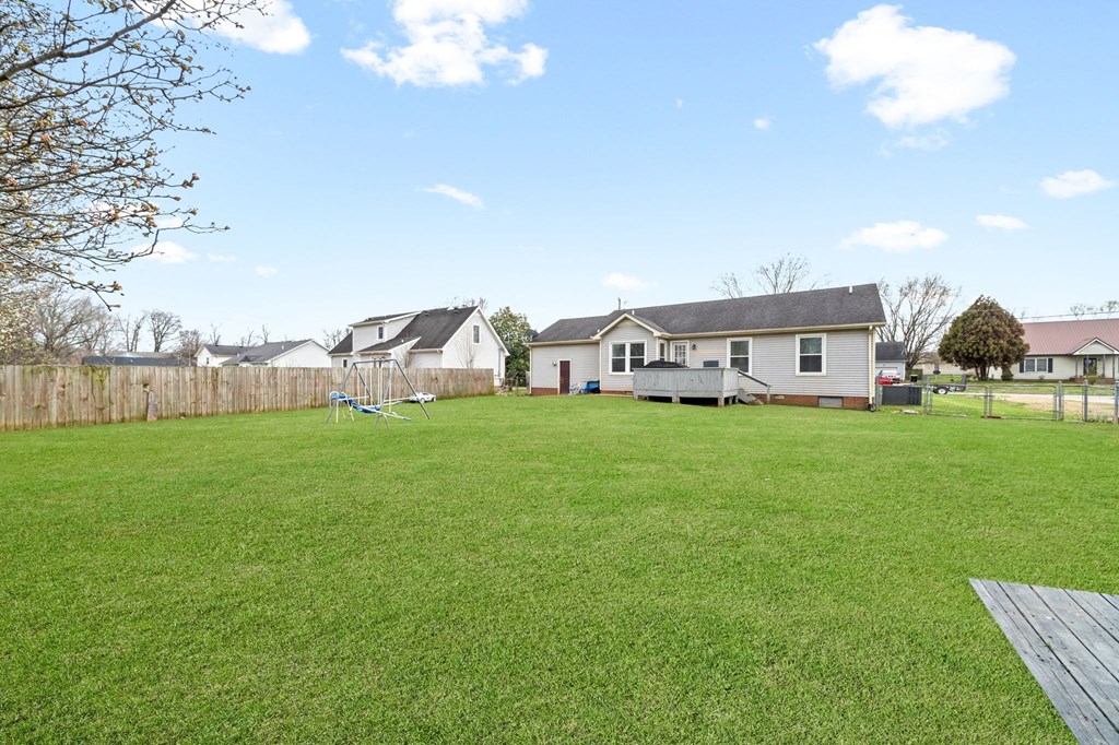 a backyard with a yard and a fence and a house