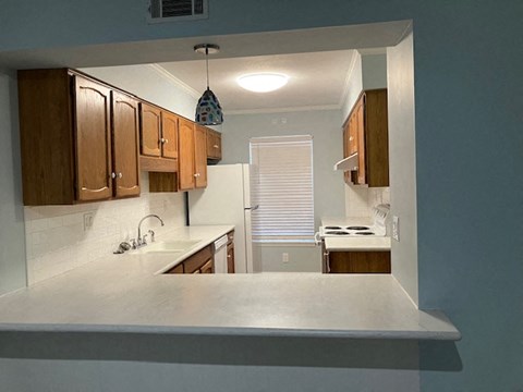 A kitchen with wooden cabinets and a white countertop.