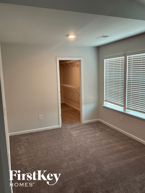 an empty room with a door to a closet and a window