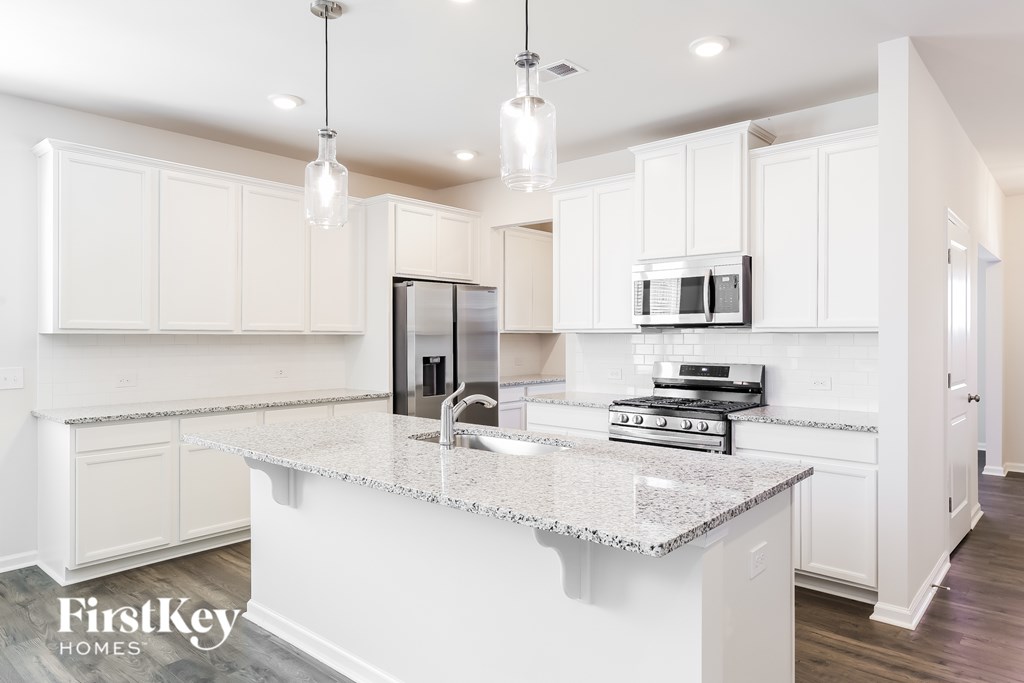 A kitchen with a granite countertop and white cabinets.