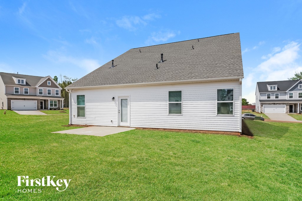 A white house with a green door and a sign that says FirstKey Homes.