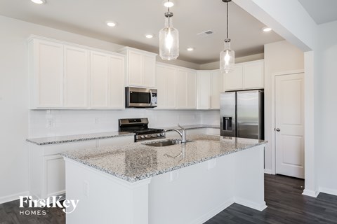 A kitchen with a granite countertop and a microwave on it.