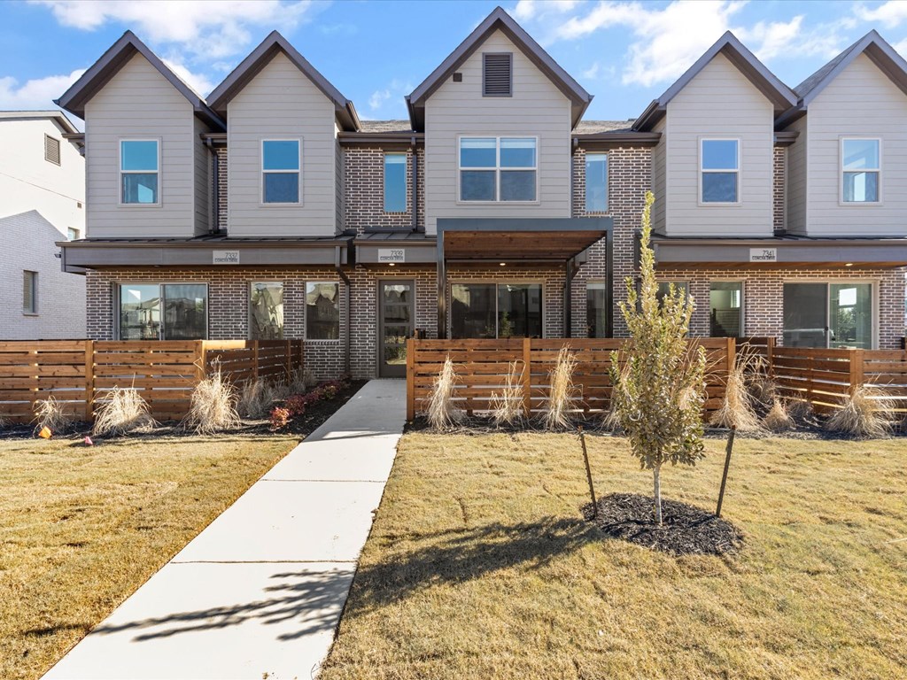 a view of a house with a sidewalk in front of it