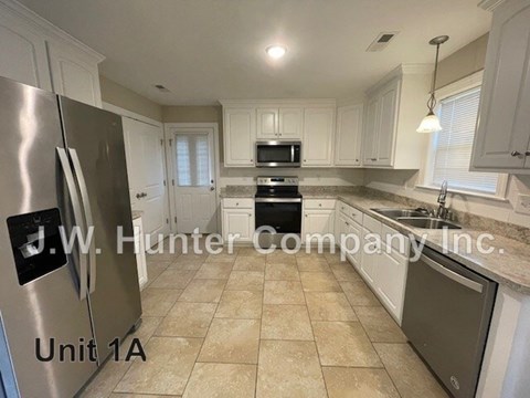 A kitchen with a refrigerator and a microwave.
