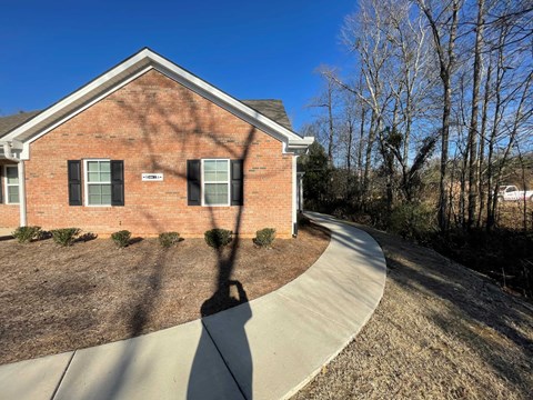 A house with a driveway and trees in the background.