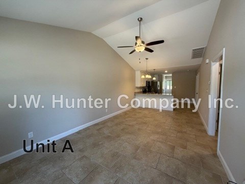 A spacious room with a ceiling fan and tiled floor.