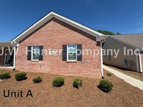 A red brick house with the label "Unit A" in front of it.